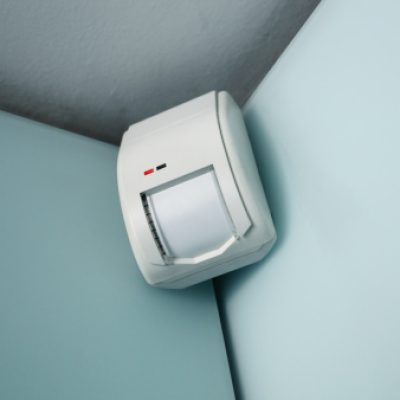 burglar alarm movement sensor mounted on a wall